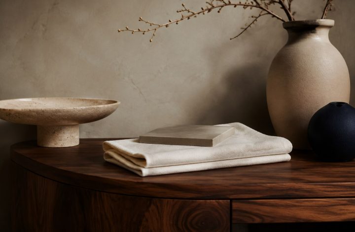 Curated interior styling detail with walnut, travertine, linen and navy ceramics